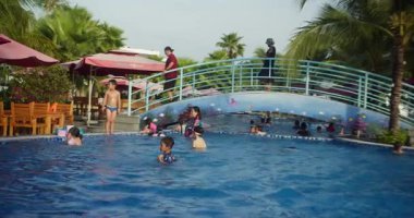 Çocuklar havuzda yüzüyorlar. Nha Trang, Vietnam - 31 Ağustos 2024: Çocuklar yüzme havuzunda yüzme tahtasıyla yüzmeyi öğreniyorlar. Yüzme tekniği. Mayo: şapkalar, mayolar ve gözlükler. eğitim.