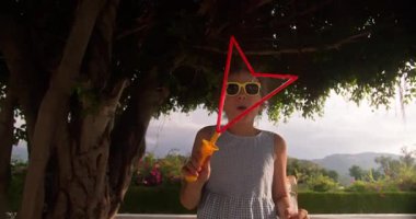 Joy Kid yaz günü sabun köpüğüyle oynuyor. Yeşil ağaçların arka planına sabun köpüğü üfleyen mutlu çocuk. Küçük çocuk doğada dinleniyor. Aile hafta sonu kavramı. Tatil sabun köpükleri
