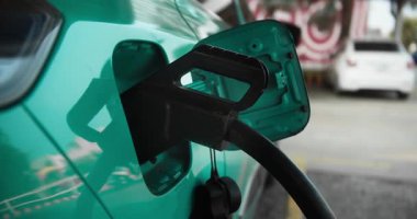 Bu yakın plan görüntü huş ağacından yapılmış elektrikli aracın şarj cihazına güvenli bir şekilde bağlandığını gösteriyor.