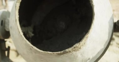 Erkek inşaat işçisi çimento karıştırıcı kullanarak yavaş çekimde beton karışımı yapıyor..