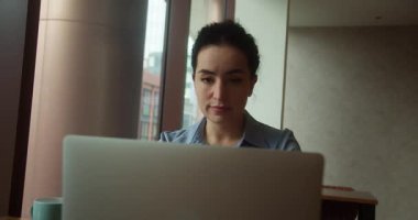 Ofiste çalışan Avrupalı bir kadın, iş kadınının dizüstü bilgisayarda iyi haberler yazmasına şaşırdı. Zafer sohbet bilgisayarı gülümsüyor.