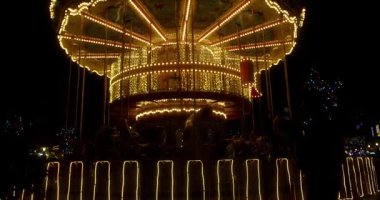 Bir aile, gece bir lunaparkta parlayan bir atlıkarıncaya biniyor. Anne, kocasını ve çocuklarını lunaparkta salıncaklara binerken telefonuyla filme çekiyor. Mutlu aile parkta eğleniyor.