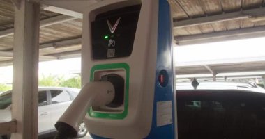 Bu görüntü, şarj cihazına güvenli bir şekilde bağlı olan elektrikli bir aracın yakın çekimini gösteriyor.