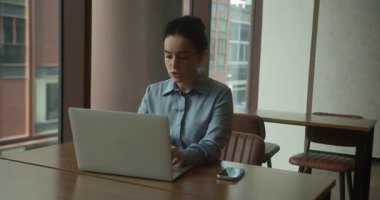 Ofiste çalışan Avrupalı bir kadın, dizüstü bilgisayarda yazı yazan yorgun bir ofis çalışanı, iş yerinde geç saatlere kadar kalan son çalışan, bilgisayar, gülümseme, iyi iş, sonuç, mutlu çalışma