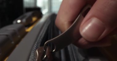 Fermuar valizde. Sarı seyahat valizinin fermuarını kapatıyorum. Tanımlanamayan parmaklar fermuarı çeker. Çanta hazırlama yolculuğu, macera ve büyüleyici keşif. Tatil hayalleri, seyahat hazırlıkları.