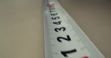 Teyp ölçümü yakın çekim. Ölçüm bandı makro, kamera yukarı hareket ediyor, kaydırma makinesiyle çekim yapıyor.