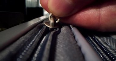 Fermuar valizde. Sarı seyahat valizinin fermuarını kapatıyorum. Tanımlanamayan parmaklar fermuarı çeker. Çanta hazırlama yolculuğu, macera ve büyüleyici keşif. Tatil hayalleri, seyahat hazırlıkları.