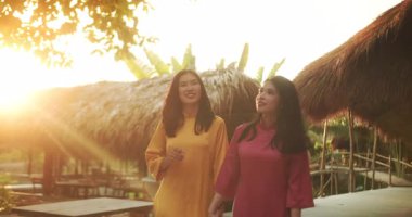 Vietnam 'daki Nha Trang şehrinde geleneksel giysileri içinde genç turistler yürüyor. Eski şehrin varoşlarında ulusal elbise ve şapkalarla dolaşan iki kız..