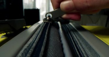 Fermuar valizde. Sarı seyahat valizinin fermuarını kapatıyorum. Tanımlanamayan parmaklar fermuarı çeker. Çanta hazırlama yolculuğu, macera ve büyüleyici keşif. Tatil hayalleri, seyahat hazırlıkları.