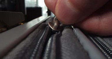 Fermuar valizde. Sarı seyahat valizinin fermuarını kapatıyorum. Tanımlanamayan parmaklar fermuarı çeker. Çanta hazırlama yolculuğu, macera ve büyüleyici keşif. Tatil hayalleri, seyahat hazırlıkları.