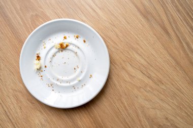 Brown cake crumbs on round white plate, top view