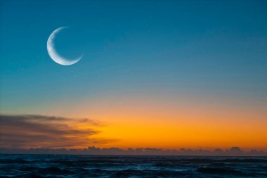 New moon or rescent above ocean.