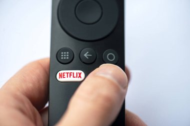 BERLIN - NOV 10: Close-up of button with Netflix logotype on a TV remote in Berlin on November 10. 2022 in Germany. Netflix, Inc. is an American subscription streaming service and production company.