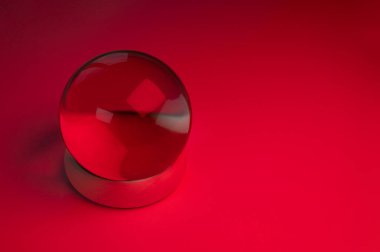 Glass crystal ball on a table with red light
