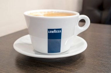 BERLIN - 23 Şubat: 23 Şubat 'ta Berlin' deki ahşap masanın üzerinde Lavazza logotype olan bir kahve fincanına yakın çekim. Almanya 'da 2022