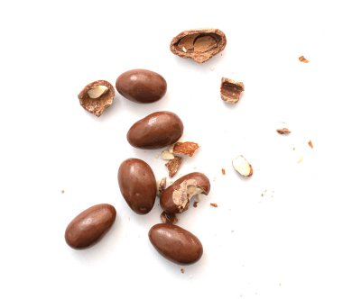 Round  and broken small chocolate candies with almond, nuts as filling isolated on white, top view