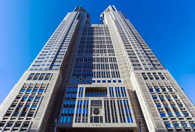 Tokyo Metropolitan Government Building with blue sky during warm sunny day clipart