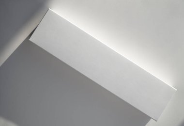 Yüzeyinde güneş ışığı olan gerçek dikdörtgen kağıt kutu. Boş bir karton paket ve ofis masasının üzerindeki gölgeler. En düşük bileşim. 