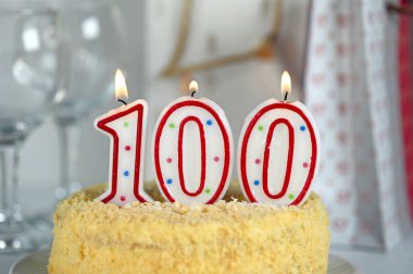 100 numaralı yanan mumla kutlama pastası.