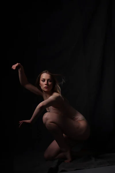 Ballerina Béžovém Obleku Tmavé Pozadí Vytesané Krásné Ženské Tělo Pose — Stock fotografie