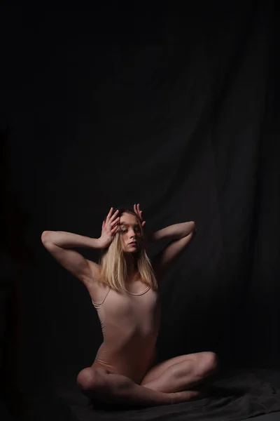 穿着米色紧身衣的芭蕾舞女 黑暗的背景雕刻的美丽的女性身体 体操运动员的皮球 — 图库照片