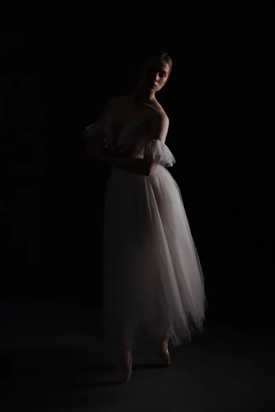 白のドレスとポイントの靴でバレリーナ 暗い背景 美しい女体 — ストック写真