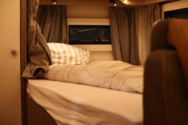 Tekerlekli karavanda bir yatak odasının iç tasarımı. Karavan, karavan. Mobil ev. Mobilya
