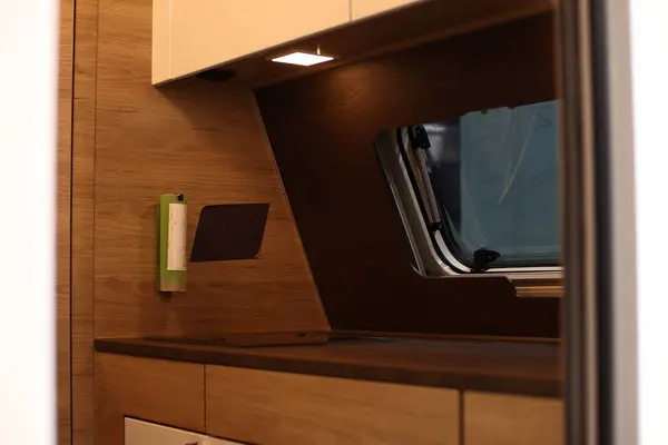Interior design of a kitchen in a camper on wheels. Caravan, motorhome. Mobile home. Stove and furniture