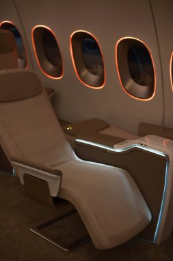 Modern kapak sınıfı koltuklu prototip uçak. Bej koltuklar ve ışıklı pencereler. İki koltuklu bir sıra. Vip uçağı.