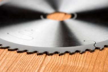 Dairesel testere bıçağı yakın plan. Tahta bir masanın üzerinde dairesel testere..