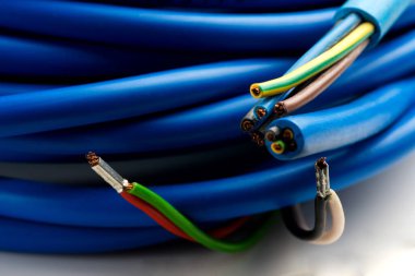 Beyaz arka planda izole edilmiş çeşitli bakır elektrik kabloları. Kablo bobinlerindeki elektrik kablosu