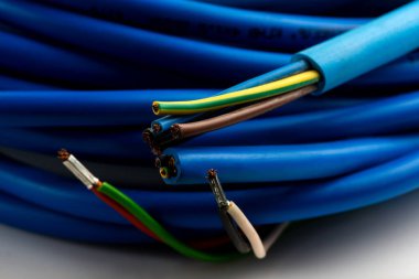 Beyaz arka planda izole edilmiş çeşitli bakır elektrik kabloları. Kablo bobinlerindeki elektrik kablosu