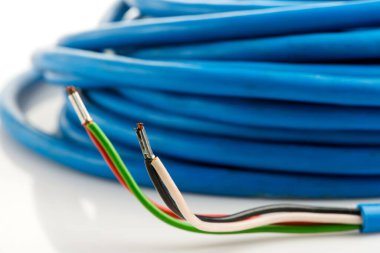 Beyaz arka planda izole edilmiş çeşitli bakır elektrik kabloları. Kablo bobinlerindeki elektrik kablosu