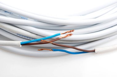 Beyaz arka planda izole edilmiş çeşitli bakır elektrik kabloları. Kablo bobinlerindeki elektrik kablosu