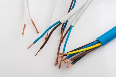 Beyaz arka planda izole edilmiş çeşitli bakır elektrik kabloları. Kablo bobinlerindeki elektrik kablosu