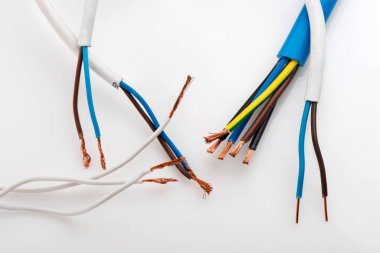 Beyaz arka planda izole edilmiş çeşitli bakır elektrik kabloları. Kablo bobinlerindeki elektrik kablosu