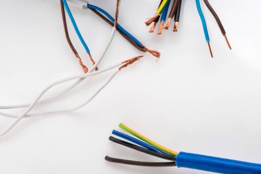 Beyaz arka planda izole edilmiş çeşitli bakır elektrik kabloları. Kablo bobinlerindeki elektrik kablosu