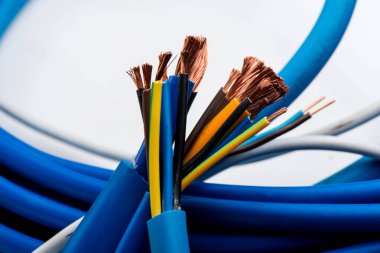 Beyaz arka planda izole edilmiş çeşitli bakır elektrik kabloları. Kablo bobinlerindeki elektrik kablosu