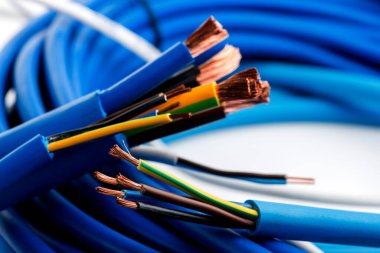 Beyaz arka planda izole edilmiş çeşitli bakır elektrik kabloları. Kablo bobinlerindeki elektrik kablosu