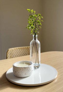 Modern İskandinav tarzı cam vazo, yeşil yapraklı vazo ve bambu masasının tepesinde fotokopi alanı olan mum.