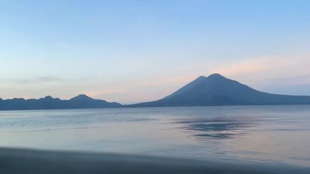 バックグラウンドの火山とアティトラングアテマラ湖の夜明けの時間の日の出Hdビデオ映像 — ストック動画
