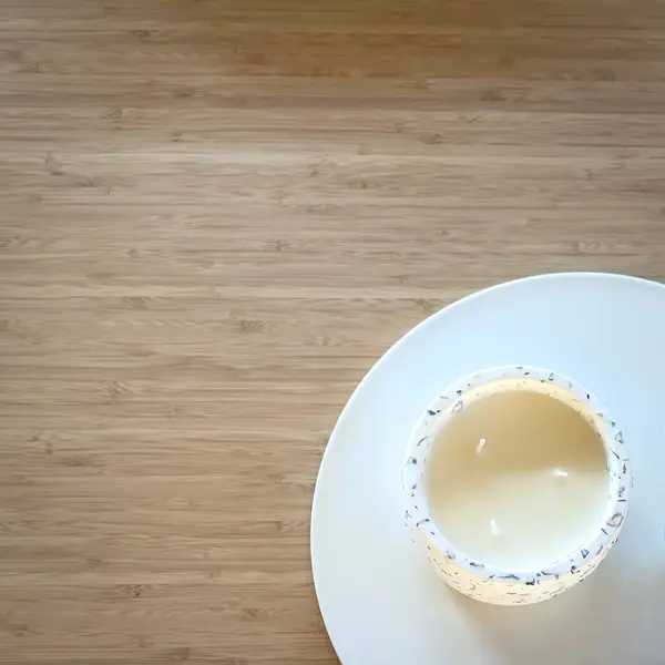 コピースペースのある木製テーブルのセラミックプレート上の白いろうそくのトップビュー — ストック写真