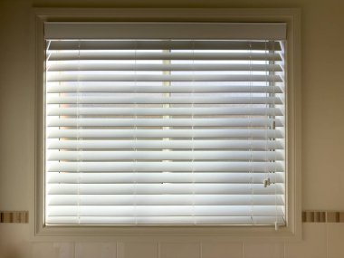 Beyaz ahşap pencere, evin içindeki ayarlama kablolarıyla kısmen açık.