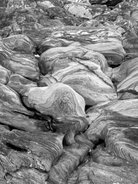 Doğal kaya şekillerinin siyah ve beyaz arka planı ve granitin içinden geçen kıvrımlı ve çizgili desenler.