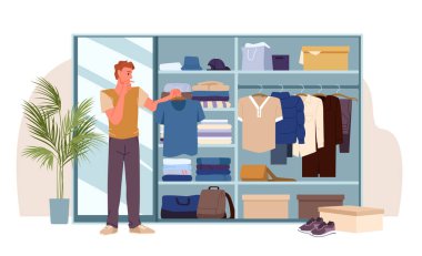 Dolapta askı ve tişört tutan genç bir adam var. Giysileri bulup seçmek ve düzenlemek için. Giysilerle gardırobu aç, dolapta şık kıyafetler giy.