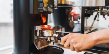 Kahve makinesinde kahve yaparken kahve makinası kullanan erkek baristaya yaklaş. Hazırlık hizmeti kavramı