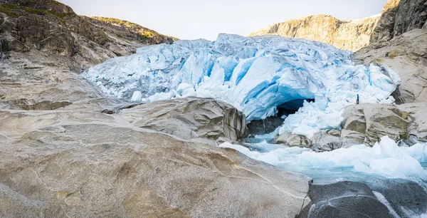Ein Mann Steht Vor Der Großen Gletscherzunge Und Dem Schmelzwasserfluss lizenzfreie Stockfotos