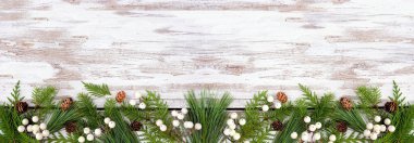 Her zaman yeşil dalları, beyaz böğürtlenleri ve kozalakları olan kışın en alt sınırı. Kopyalama alanı olan kırsal beyaz ahşap afiş arkaplan üzerindeki üst görünüm.