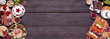 Noel şarküterisi koyu renk ahşap bir afişle sınırlandırılmış. Peynir ve meze çeşitleri. Noel ağacı, çelenk ve şeker kamışı düzenlemeleri. Boşluğu kopyala.