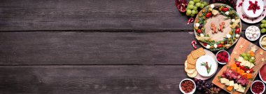 Noel şarküteri yan sınırında, koyu renk ahşap bir afiş var. Peynir ve meze seçimi. Noel ağacı ve çelenk düzenlemeleri. Boşluğu kopyala.